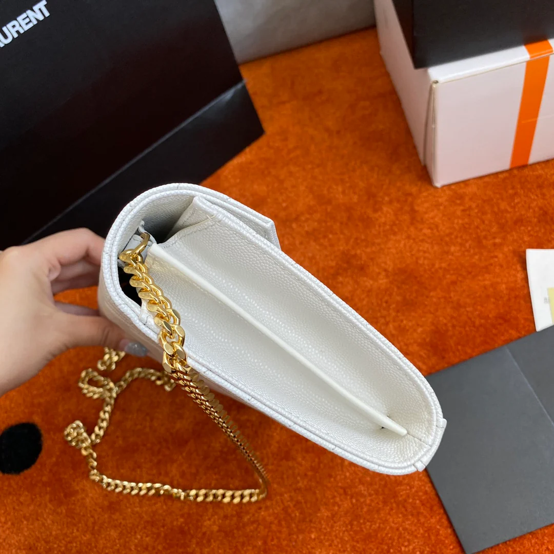 Сумочка-конверт YSL с монограммой из икры — белая с золотой фурнитурой.