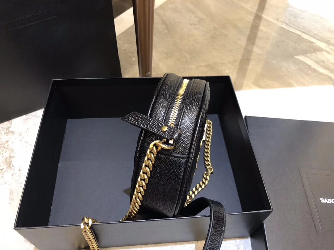 Маленькая круглая сумка YSL Vinyle - черная с золотой фурнитурой.