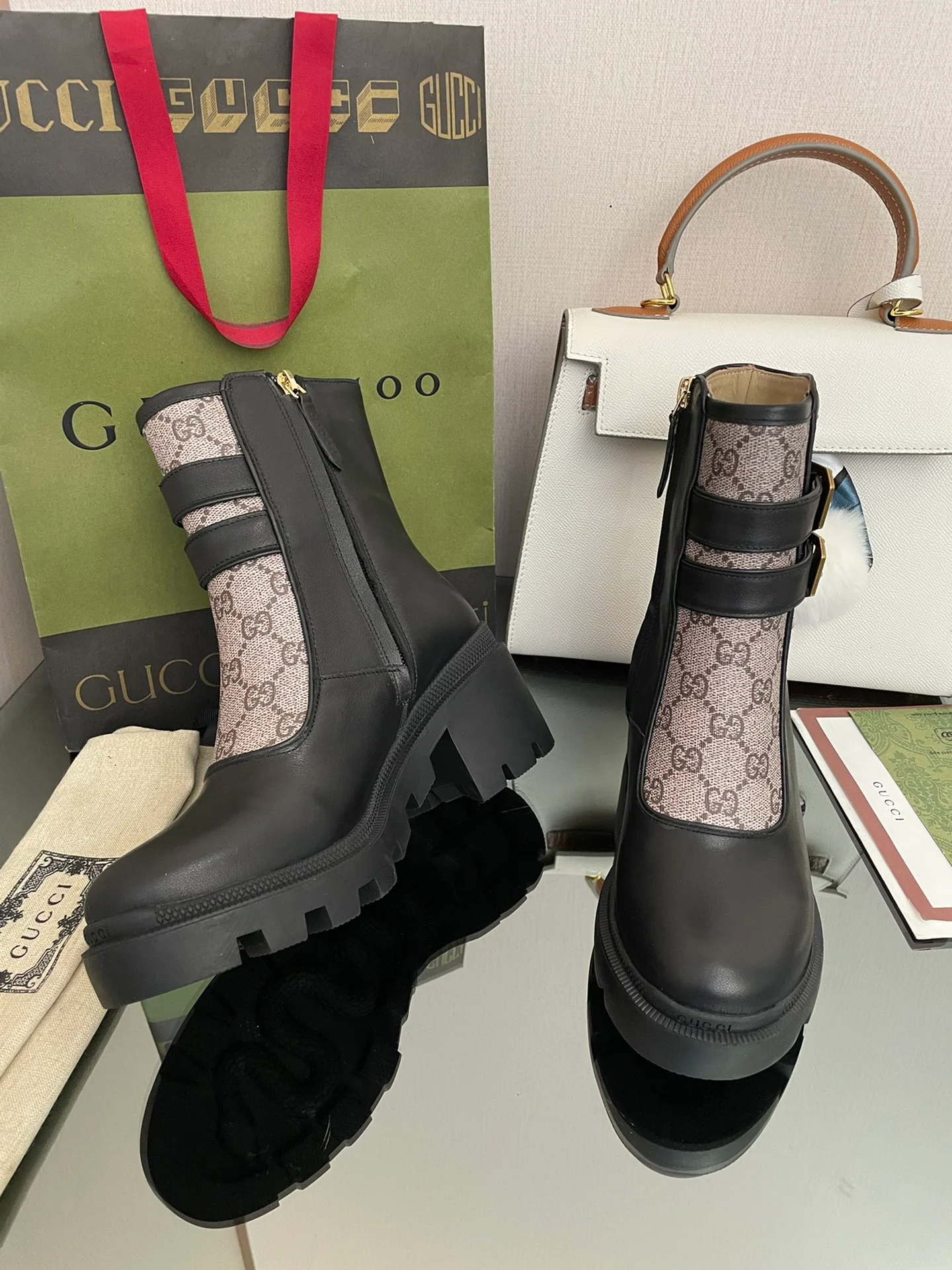 Сапоги Gucci на массивном каблуке до середины икры с монограммой — черные и бежевые.