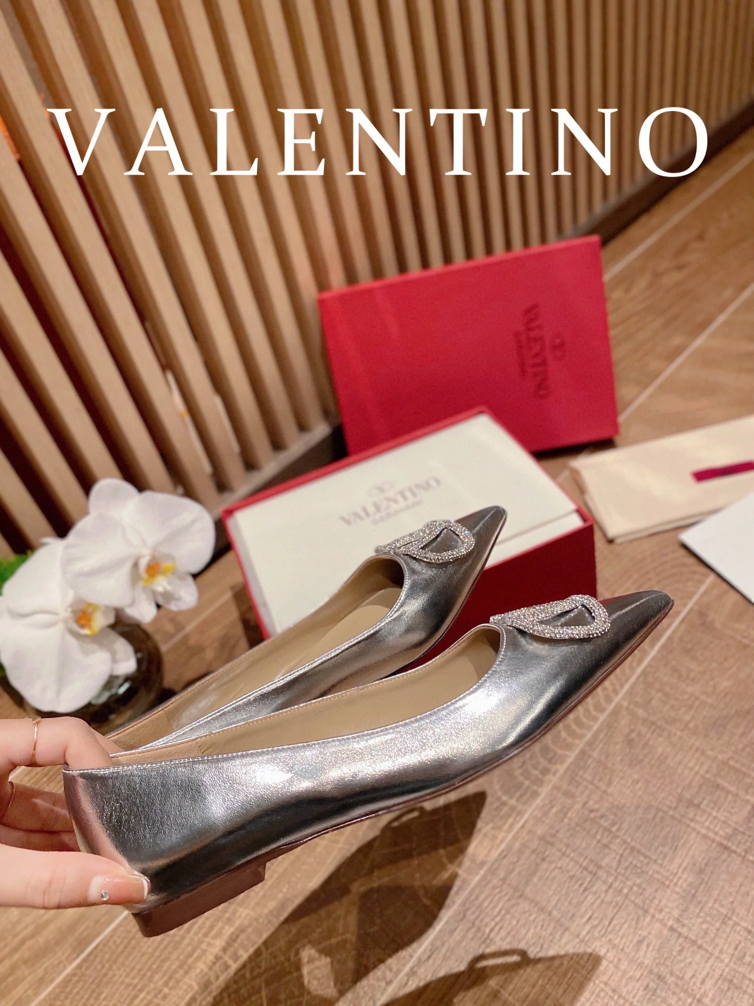 Туфли Valentino на каблуке с V-образным вырезом и бриллиантовой пряжкой — серебристые.