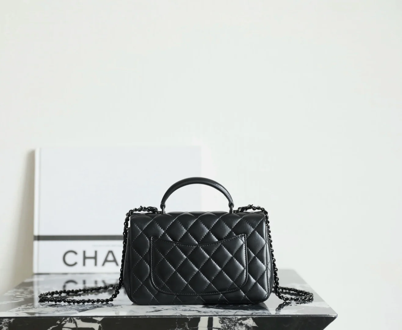 Мини-сумочка Chanel 25p-CF с клапаном — черная с черной пряжкой.