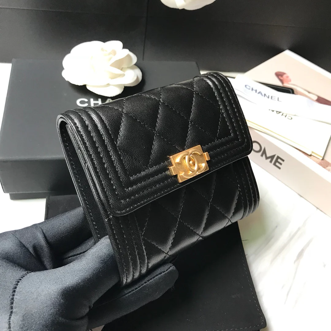 Кошелек Chanel Le Boy Tri-fold Wallet — из черной овечьей кожи с золотой пряжкой.