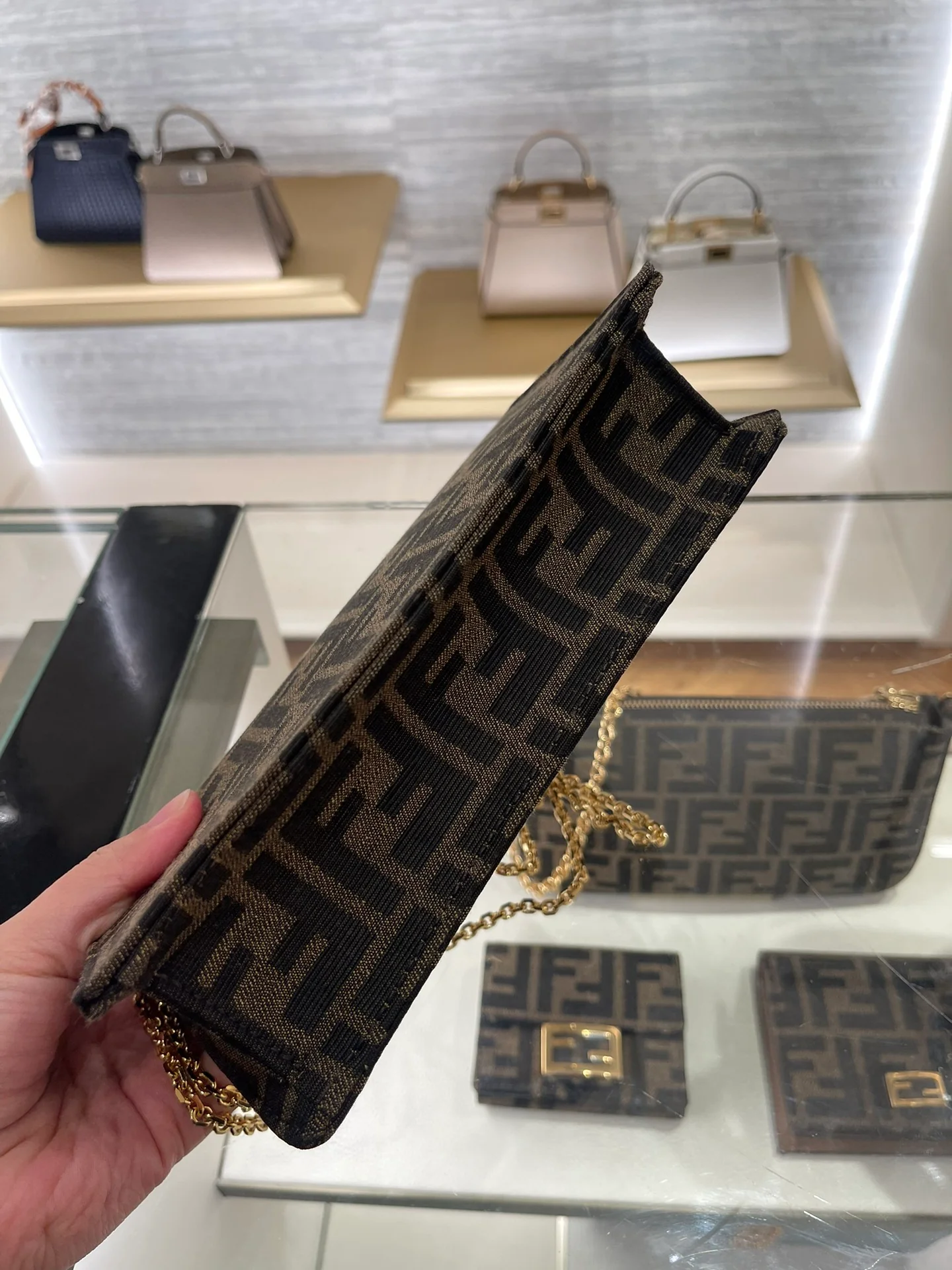 Сумка Fendi с монограммой и цепочкой под мышкой