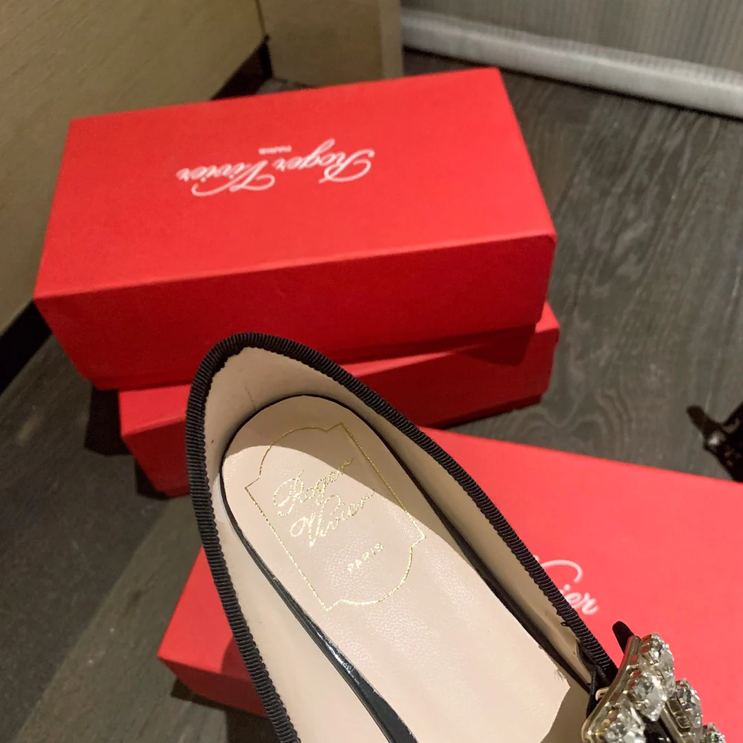 Лакированные балетки с пряжками, украшенными стразами — черные.