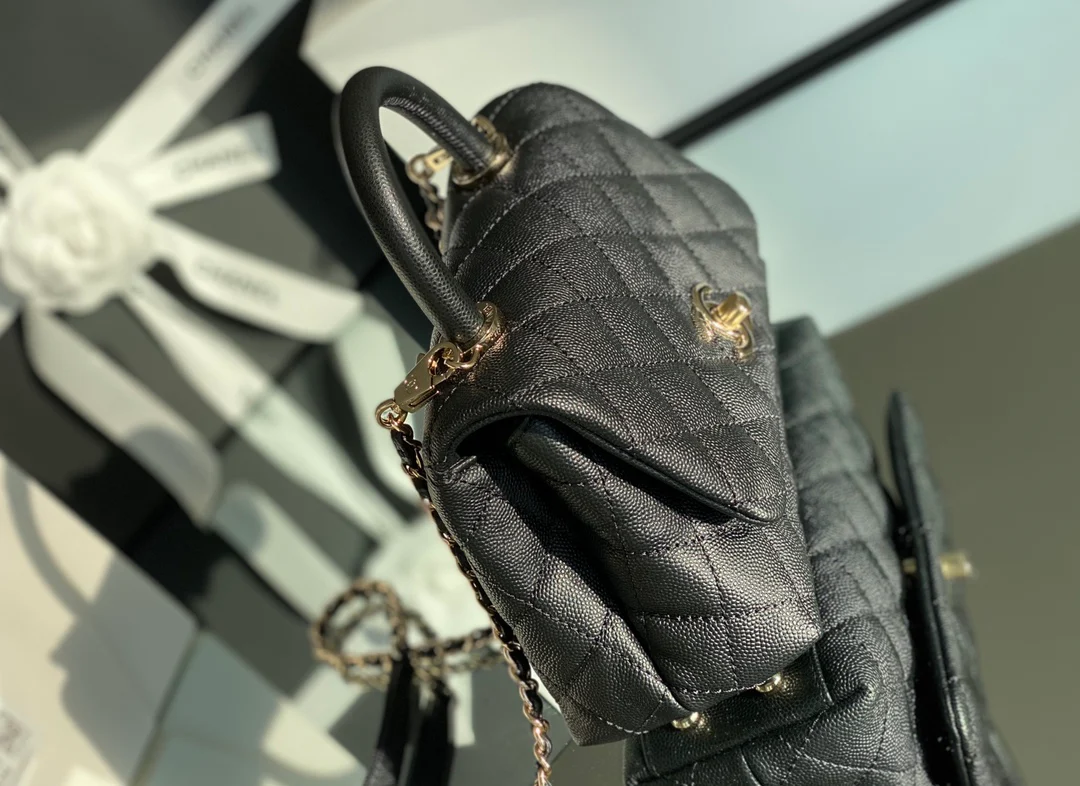 Мини-сумка Chanel Coco Handle — черная кожа с золотистой пряжкой.