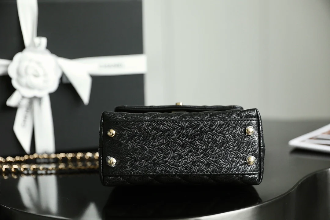 Мини-сумка Chanel Coco Handle — черная кожа с золотистой пряжкой.