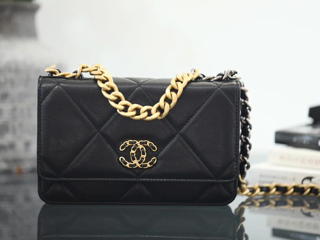 Сумка Chanel WOC из 19-й коллекции - из черной овечьей кожи с золотой пряжкой.