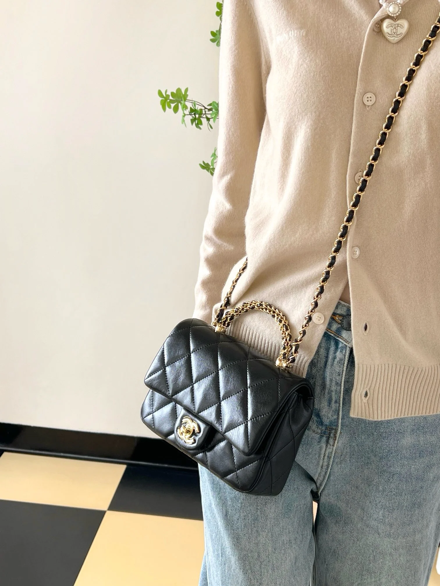 Маленькая черная сумка Chanel с клапаном и поворотной ручкой.