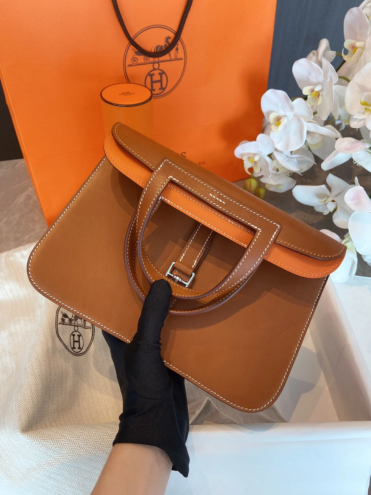 Кожаная сумка Hermes Halzan 25 с оранжевыми акцентами и серебряными пряжками.