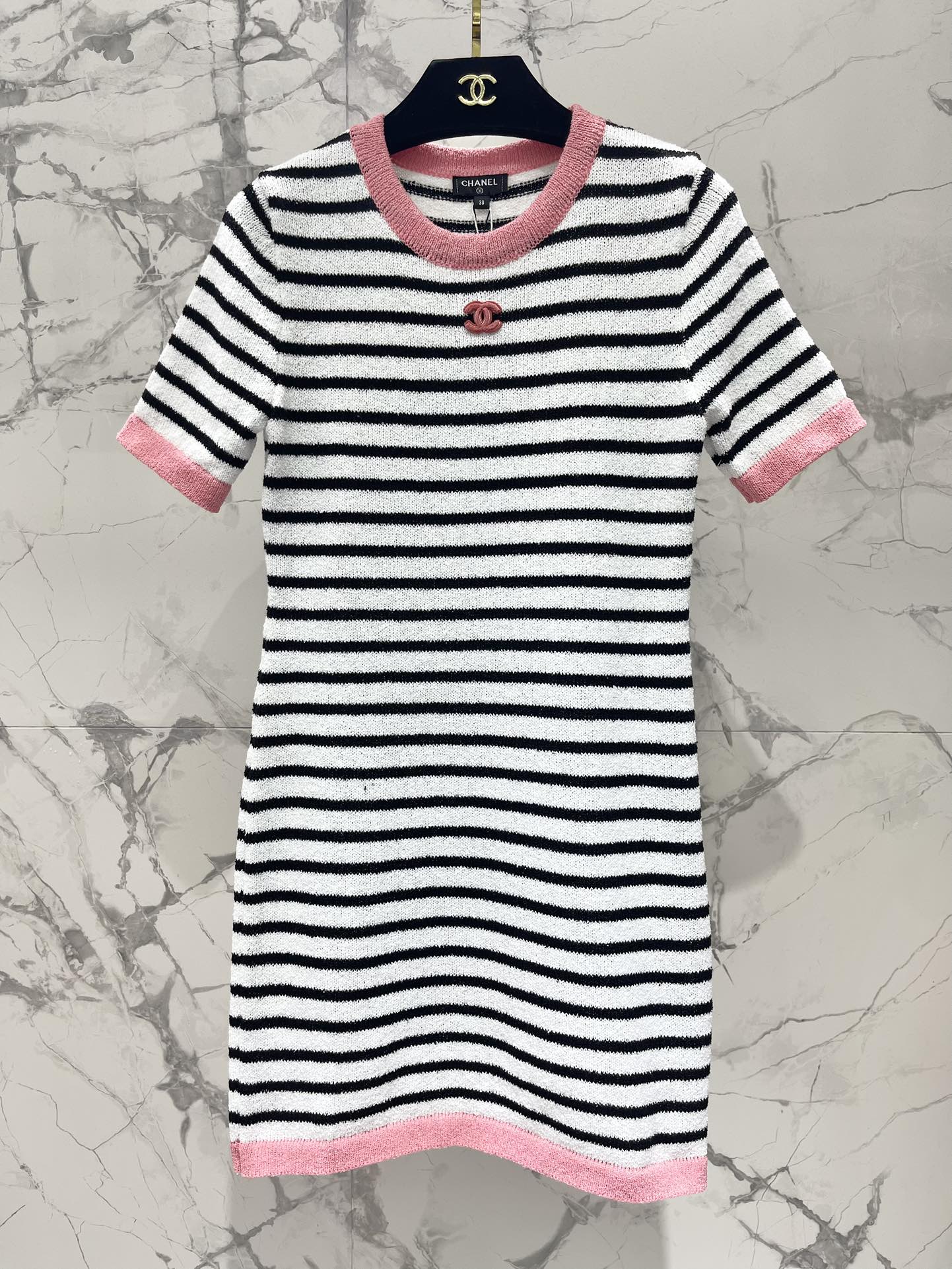 Новинка весны 2024 года от Chanel - универсальный и стройнящий вязаный комбинезон в розовую полоску с круглым вырезом и короткими рукавами, с вышивкой логотипа на груди.