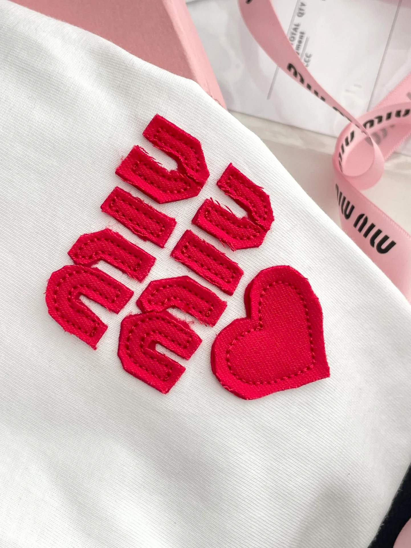 Miu Miu-2404 - Простая футболка с коротким рукавом и красной аппликацией в виде надписи.