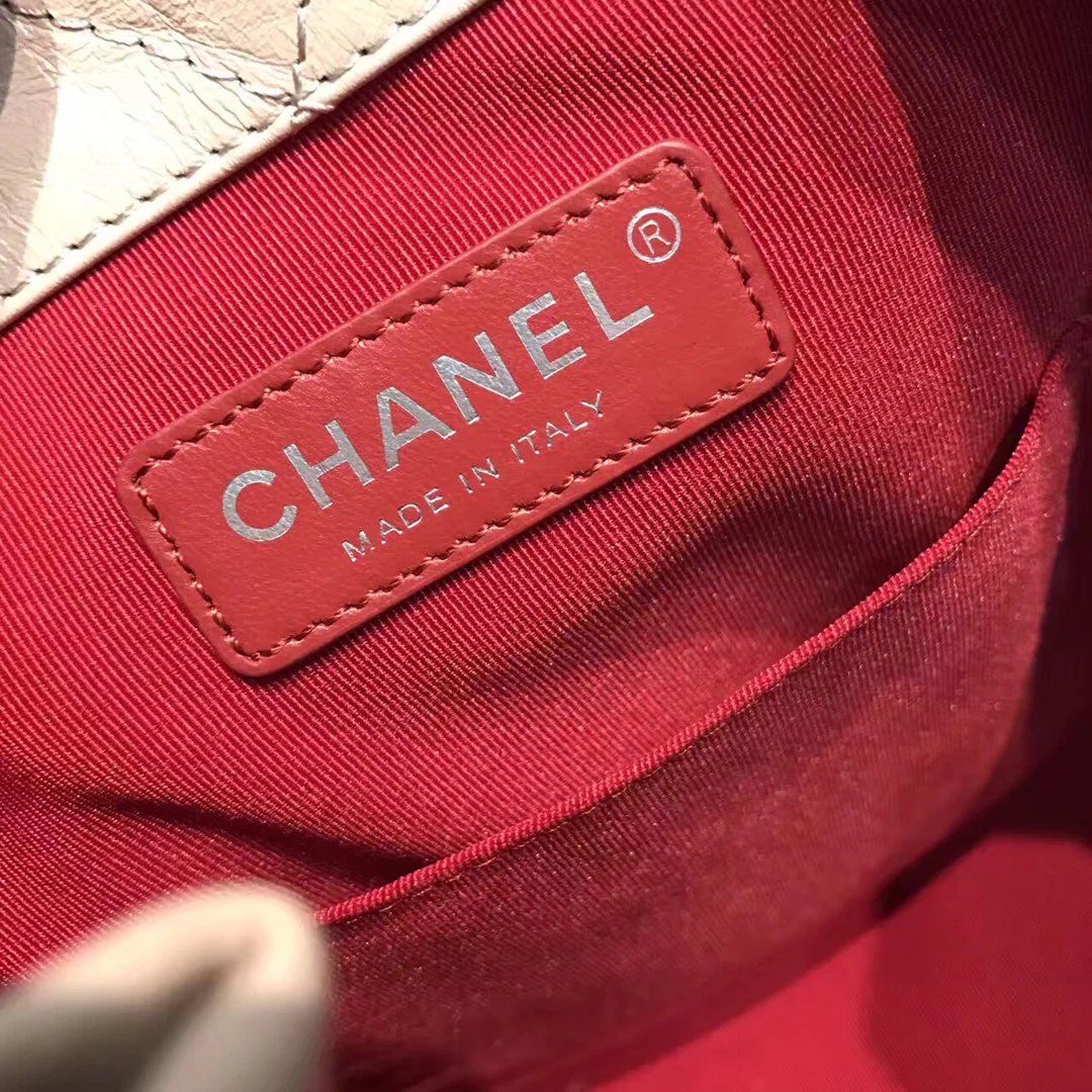 Маленький рюкзак-хобо Chanel — бежевый и черный.