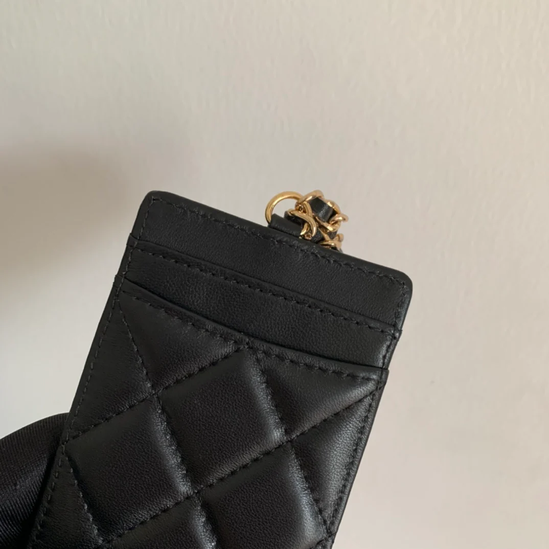 Держатель для удостоверений личности Chanel — из черной овечьей кожи с золотой пряжкой.