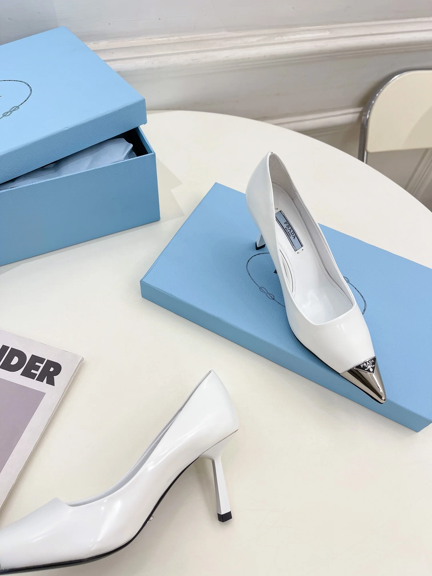 Новинка весны 2023 года от Prada - туфли на высоком каблуке с острым носком - белые.