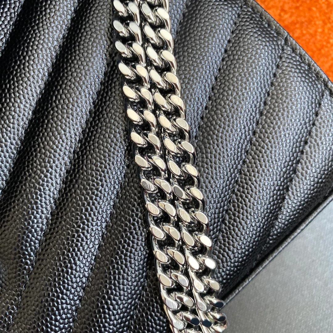 Сумка-конверт YSL с монограммой из икры — черная с серебристой фурнитурой.