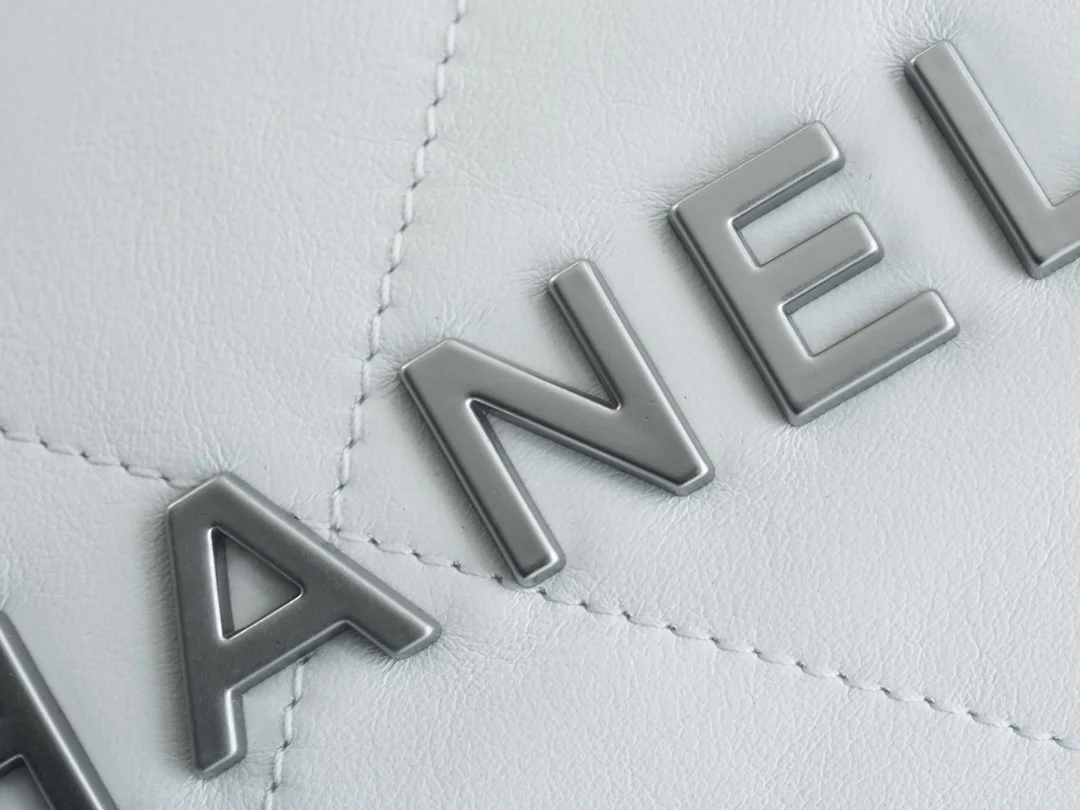 Сумочка Chanel No. 22 — маленькая, белая, серебристая.