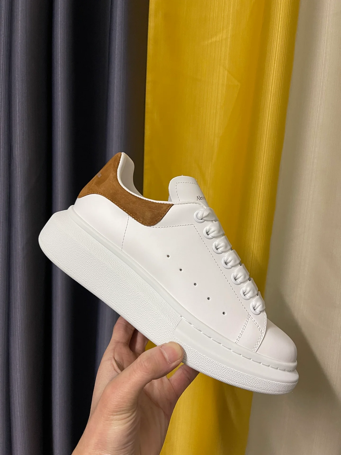 Классические белые кроссовки McQueen с коричневой замшевой подошвой на каблуке.