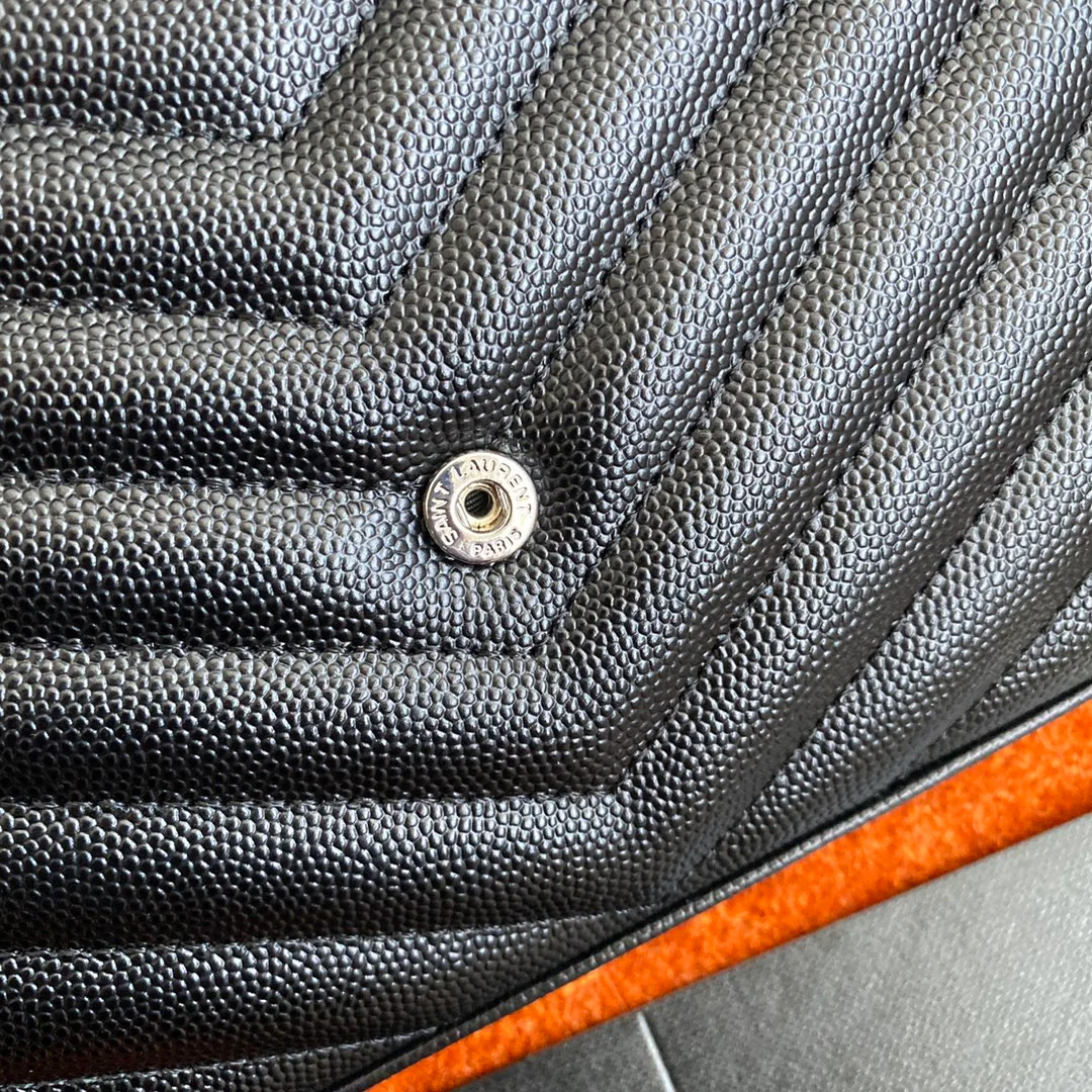 Сумка-конверт YSL с монограммой из икры — черная с серебристой фурнитурой.