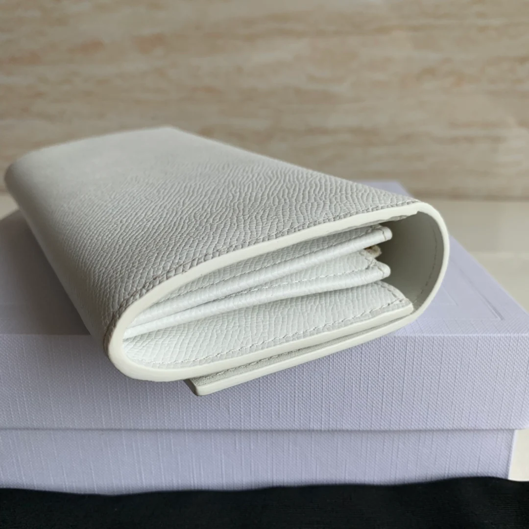 Кошелек-книжка Celine - кремовый с принтом в виде пальмовых листьев.