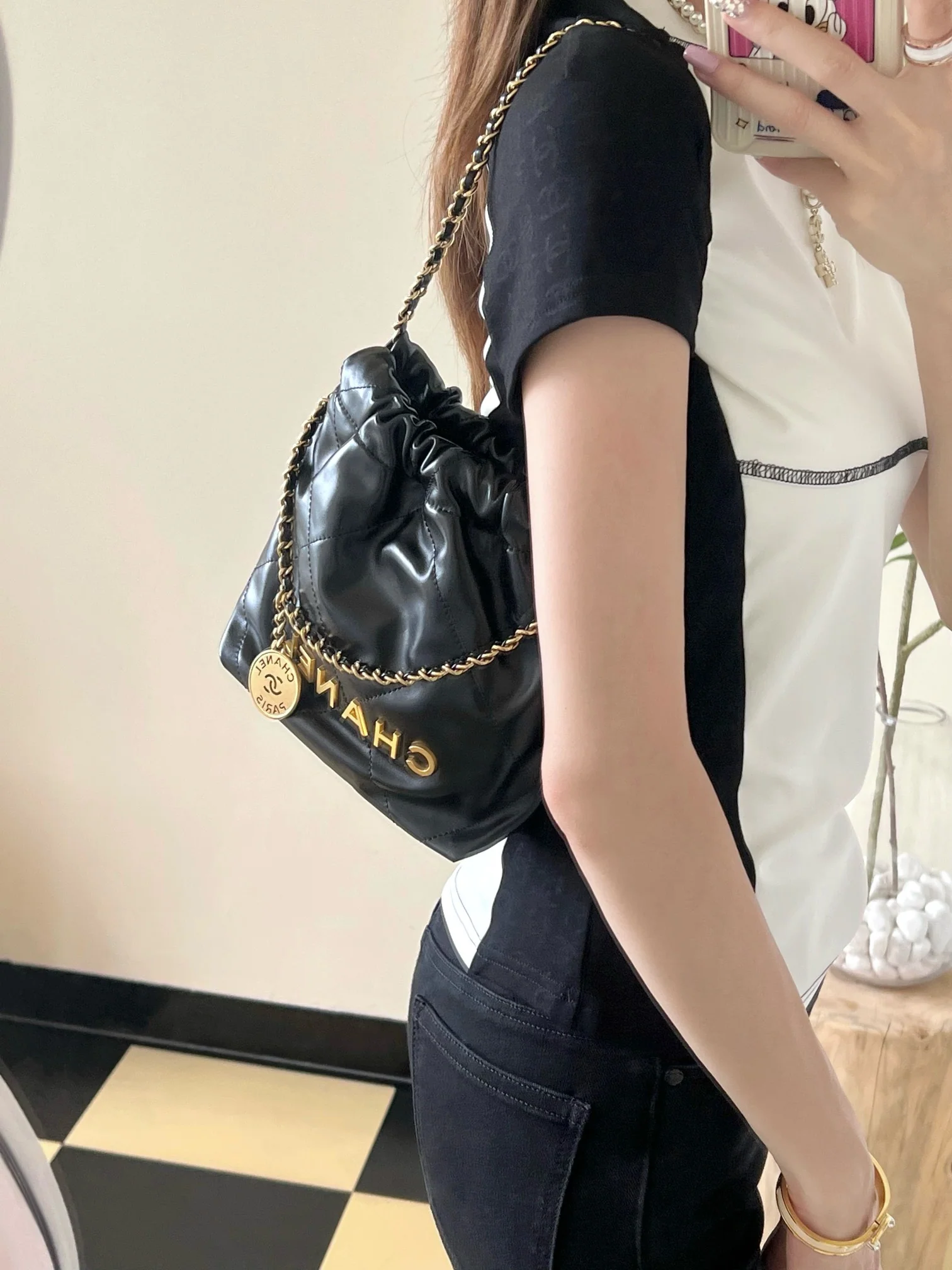 Мини-сумочка Chanel 22 – черная с золотой фурнитурой.