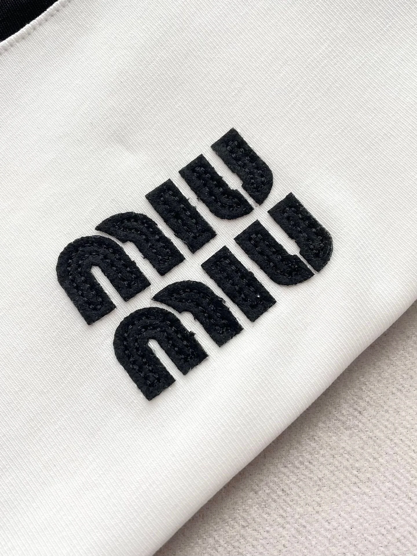 Футболка Miu Miu 2404 с коротким рукавом и принтом в виде букв, с черной отделкой.