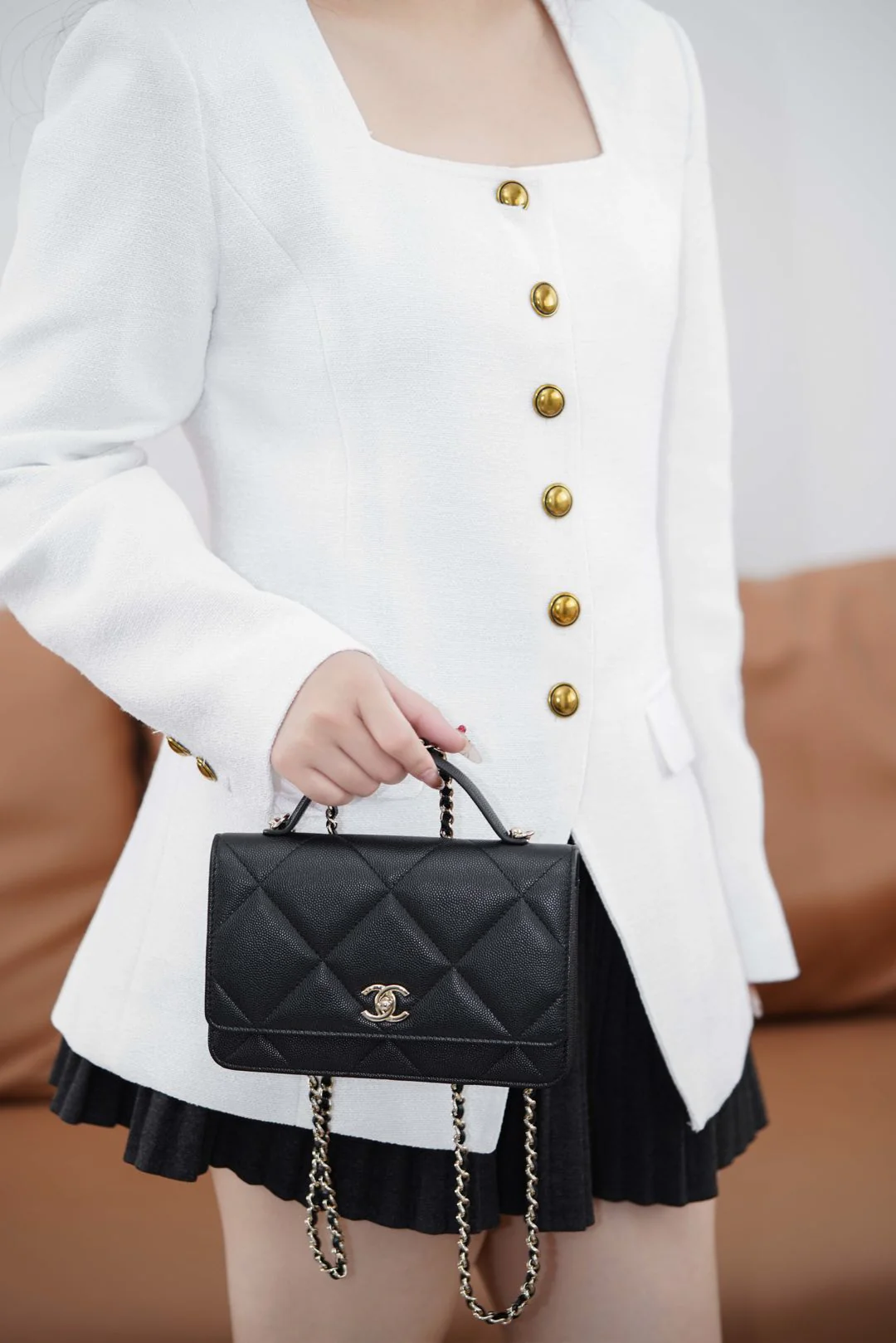 Ручка сумки Chanel из 25-каратного золота с ромбовидным узором, черная сумка-корзина с золотой фурнитурой.