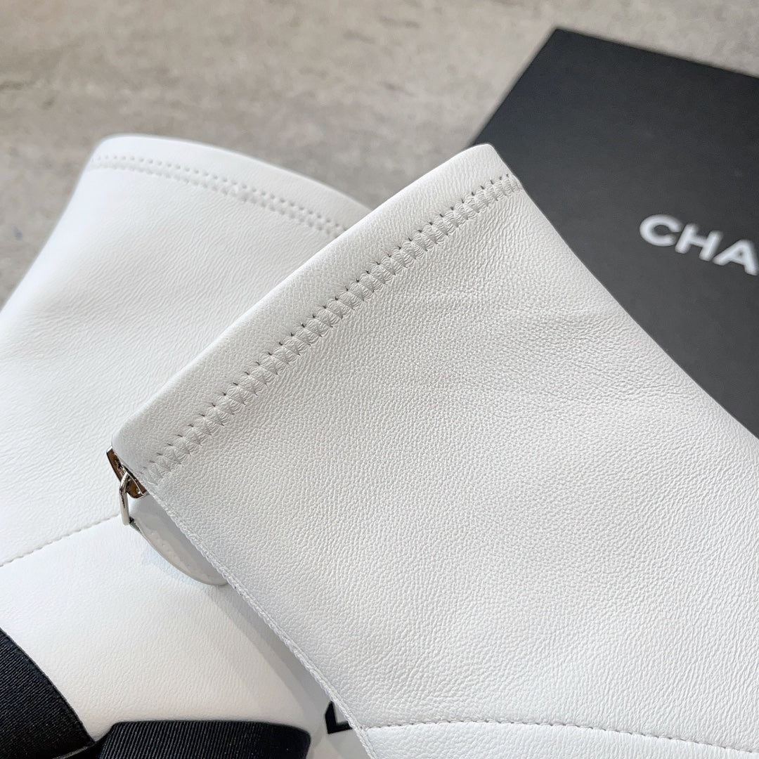 Новинка из коллекции Chanel Pre-Fall 2023 — образ с парижского подиума — ботильоны с бантом — белые.