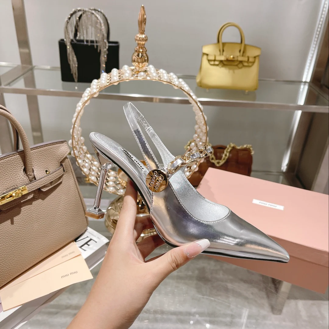 Новинка осенне-зимней коллекции Miu Miu 2022 — туфли на высоком каблуке с острым носком и вырезом на пятке — серебристые.