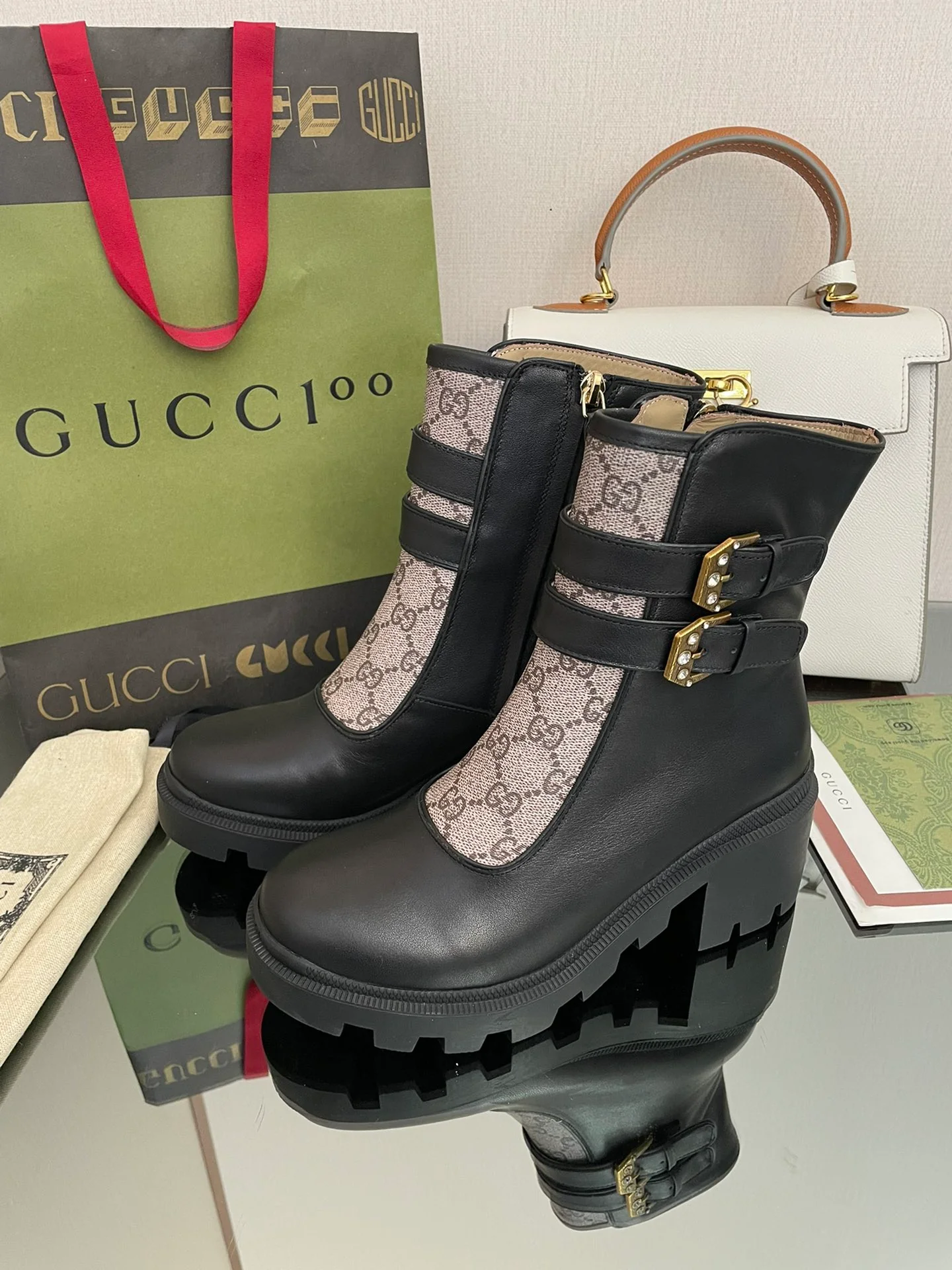 Сапоги Gucci на массивном каблуке до середины икры с монограммой — черные и бежевые.