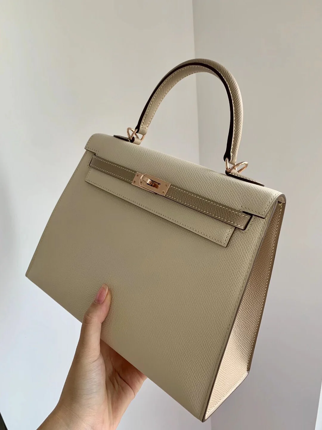 Hermes Kelly 25 Epsom Milkshake White с серым тренчем и пряжками из розового золота.