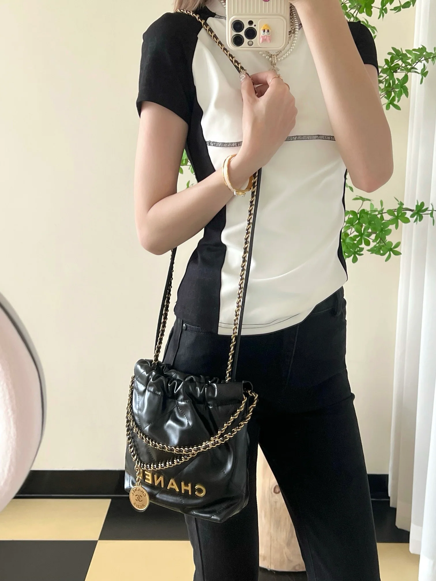 Мини-сумочка Chanel 22 – черная с золотой фурнитурой.