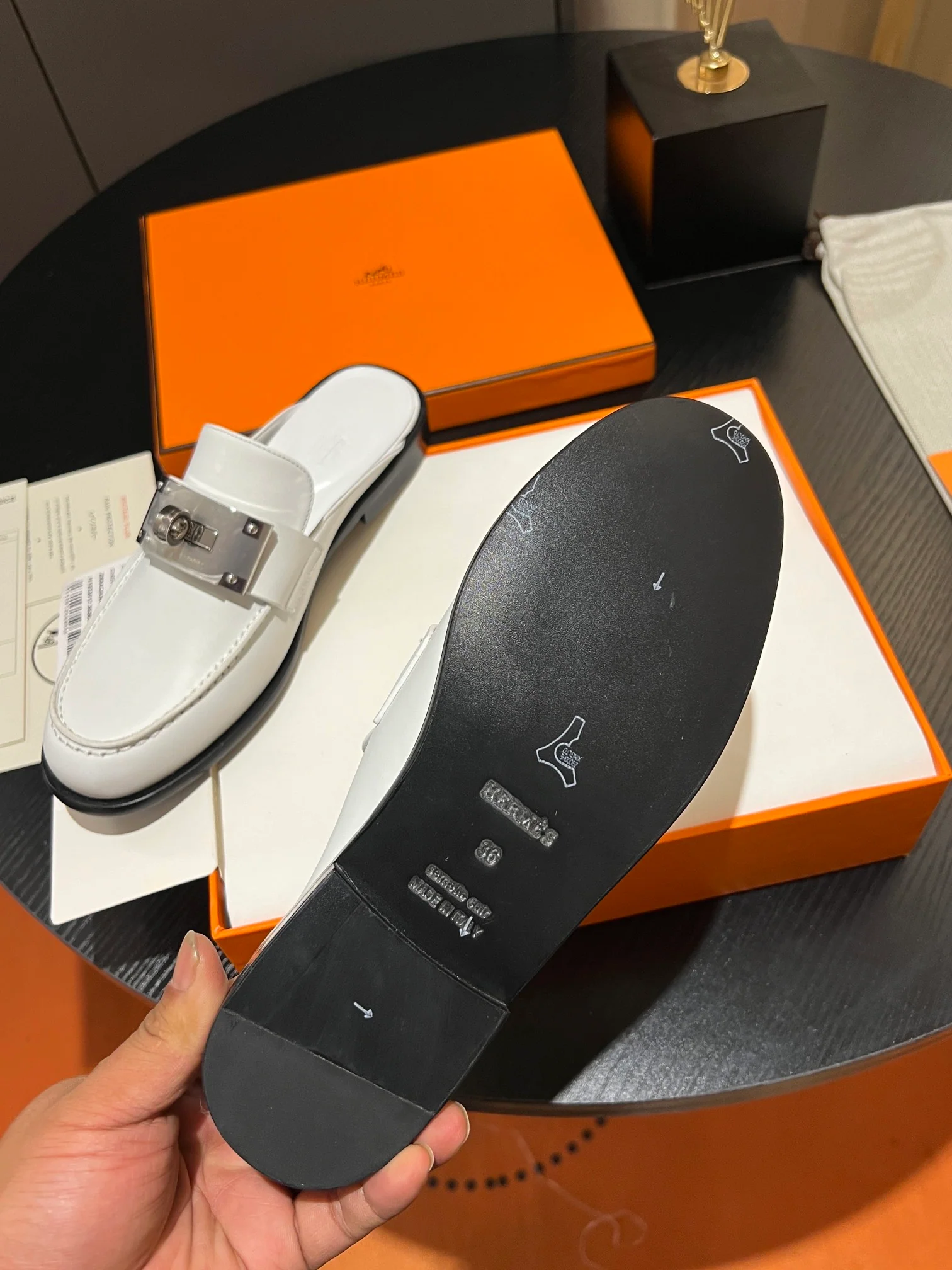 Мюли Hermes 2024 с металлической пряжкой в ??виде буквы H — белые.