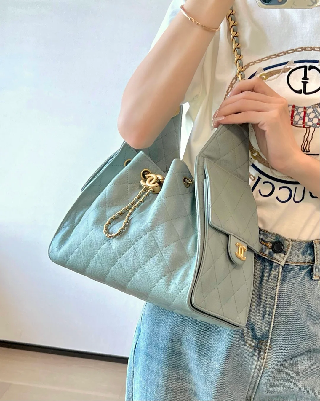 Маленькая сумка-шоппер Chanel — серо-голубая с золотой фурнитурой.