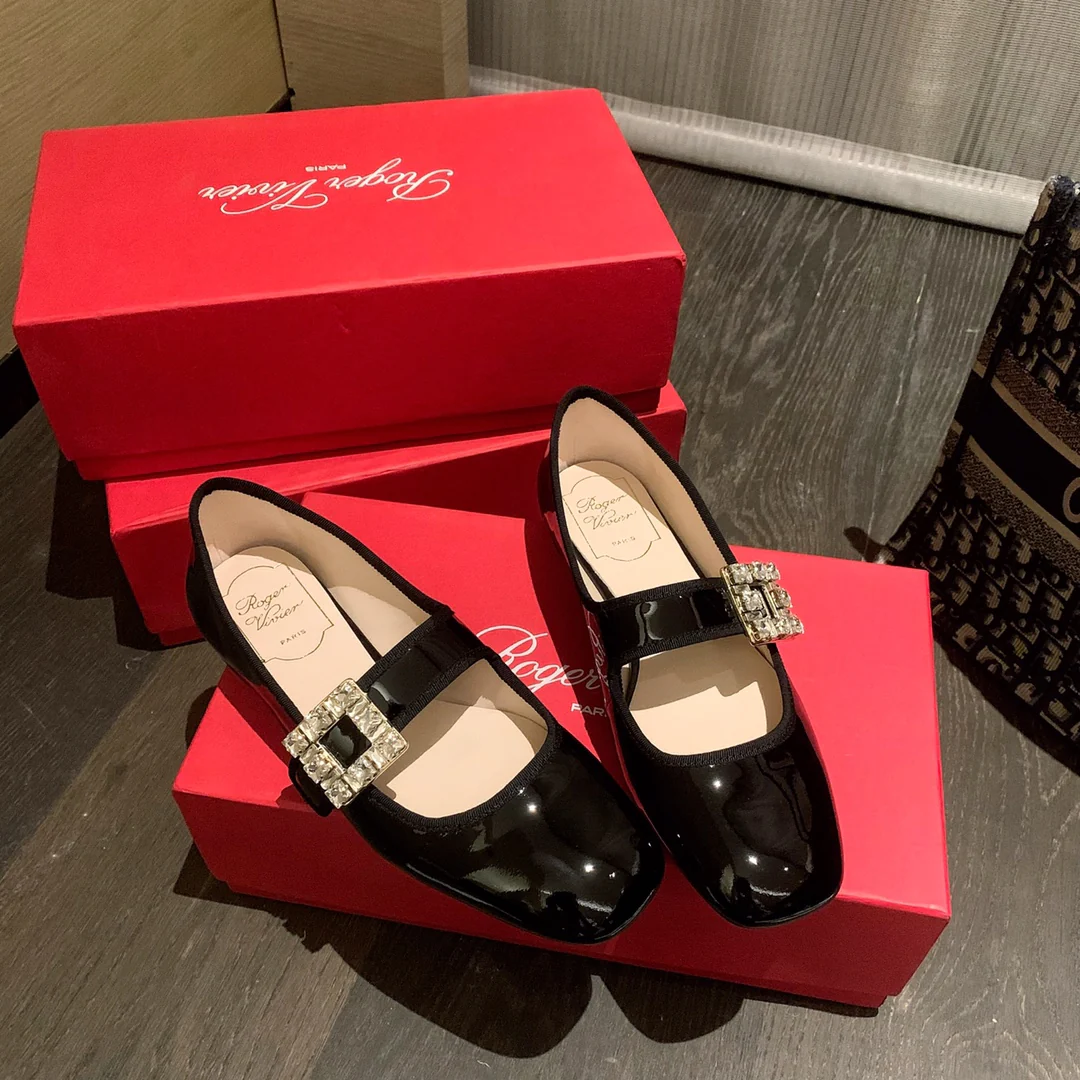 Лакированные балетки с пряжками, украшенными стразами — черные.