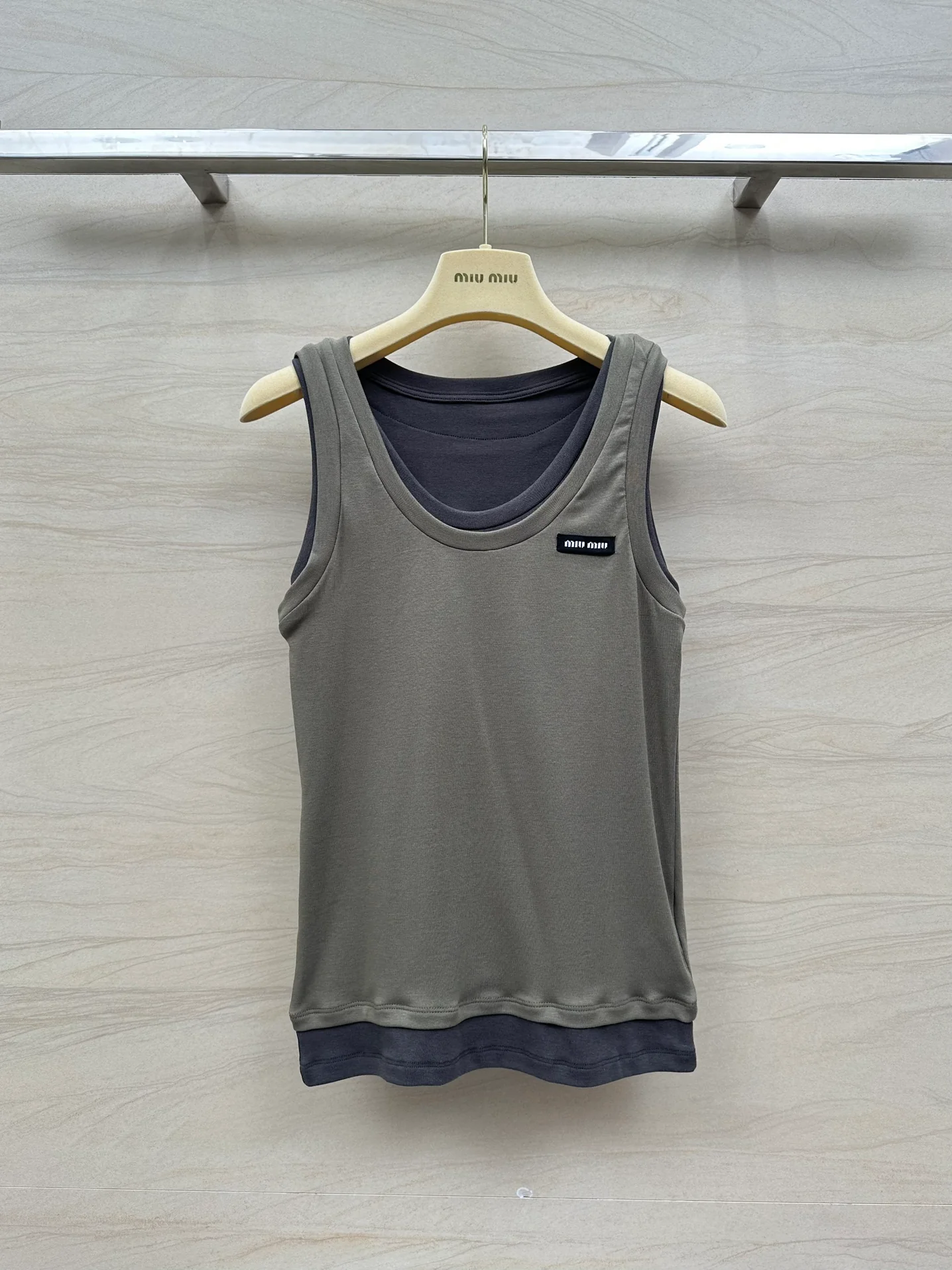 Новинка сезона весна/лето 2024 от Miu Miu: многослойный, культовый универсальный жилет — серо-коричневый.