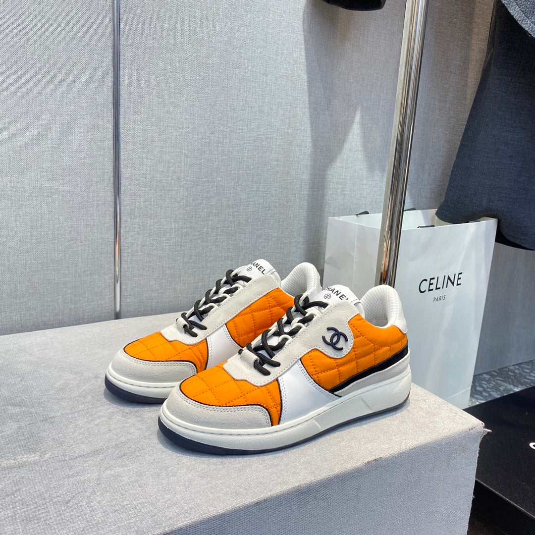 Коллекция Chanel ?Ранняя весна 2023? — повседневные кроссовки со стразами — оранжевые.