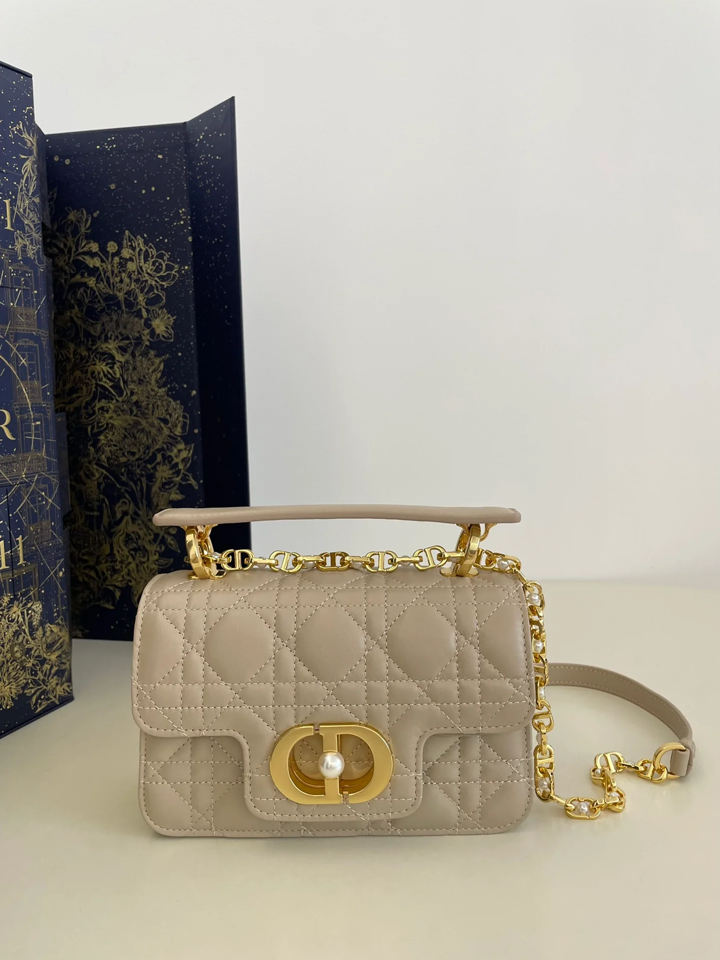 Сумочка Dior Jolie из серии с жемчужной цепочкой, абрикосового цвета, маленького размера.