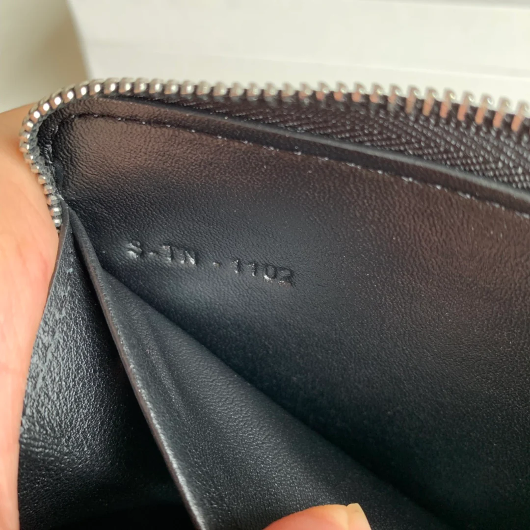 Длинный кошелек Celine на молнии — черный с узором в виде ряби на воде.