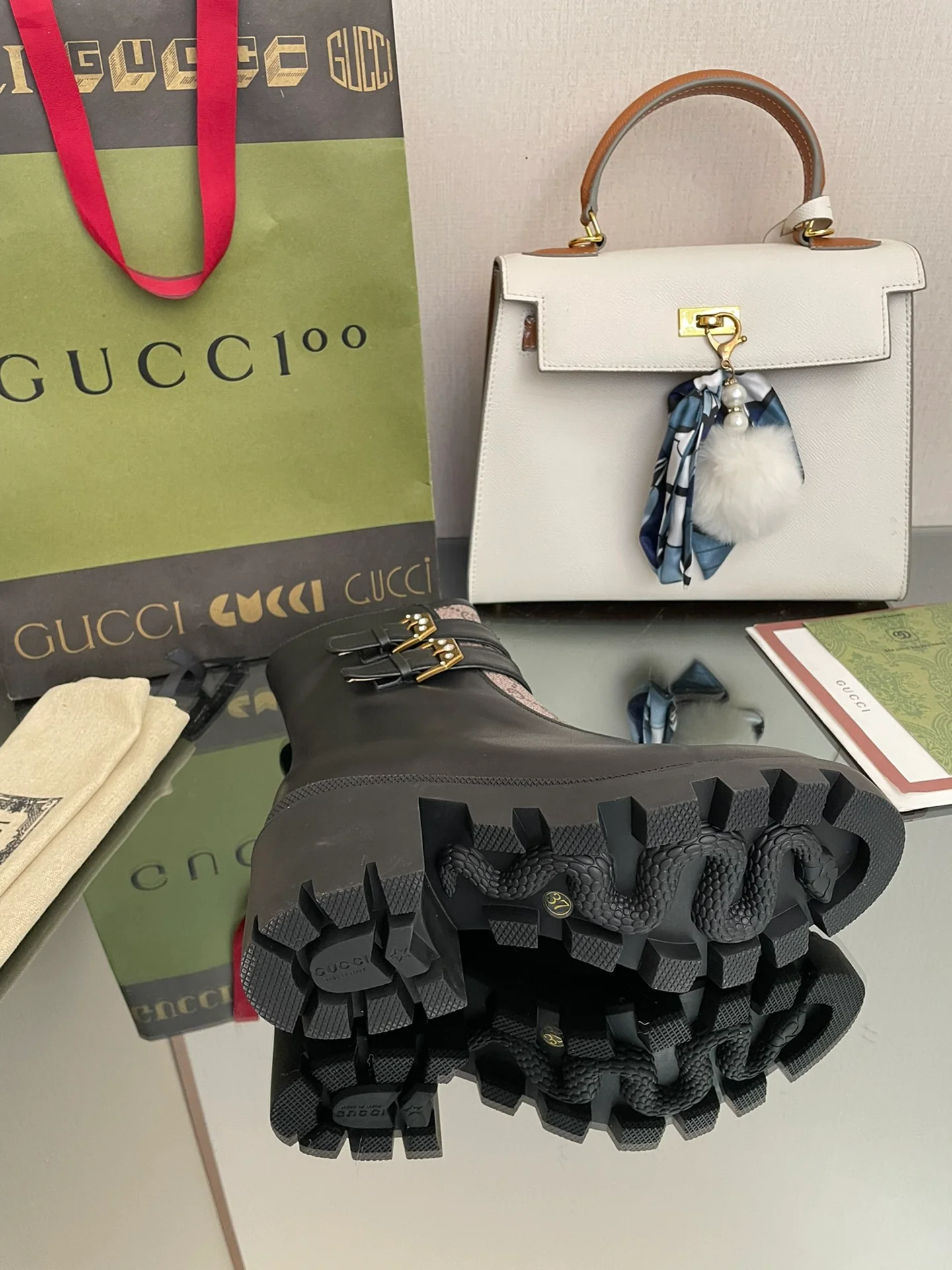 Сапоги Gucci на массивном каблуке до середины икры с монограммой — черные и бежевые.