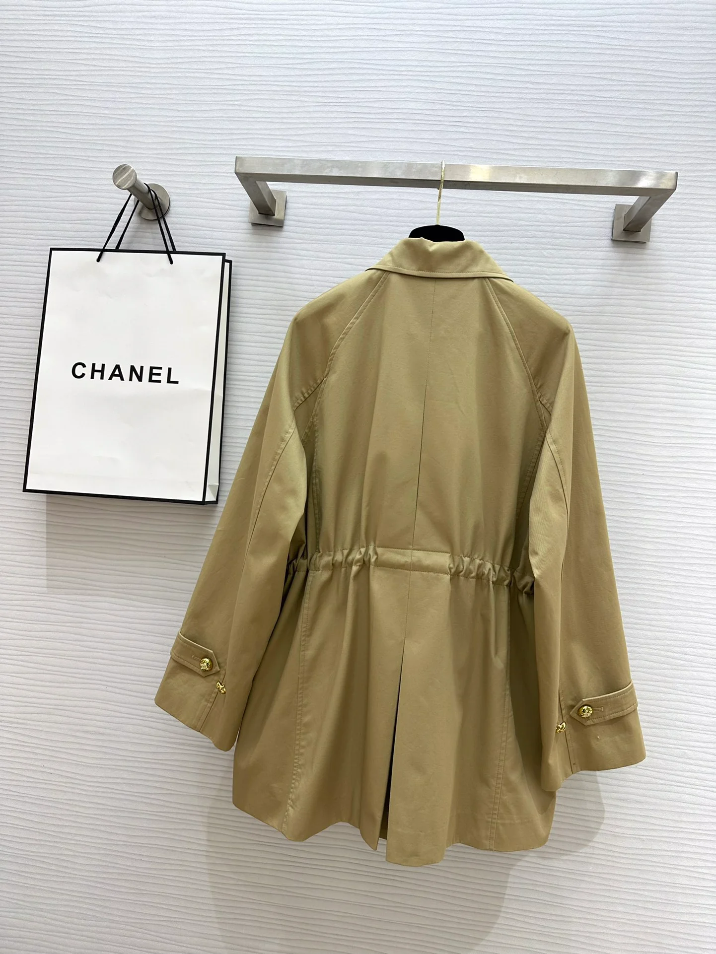 Новая коллекция Chanel весна/лето 2024: двубортный тренч, украшенный цепочками.