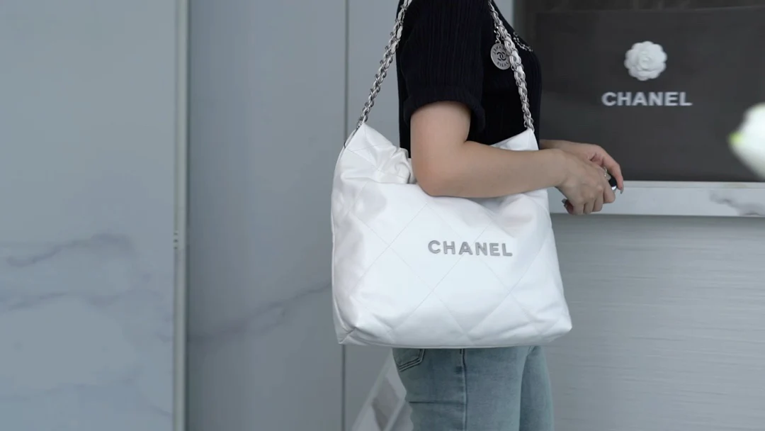 Сумочка Chanel No. 22 — маленькая, белая, серебристая.