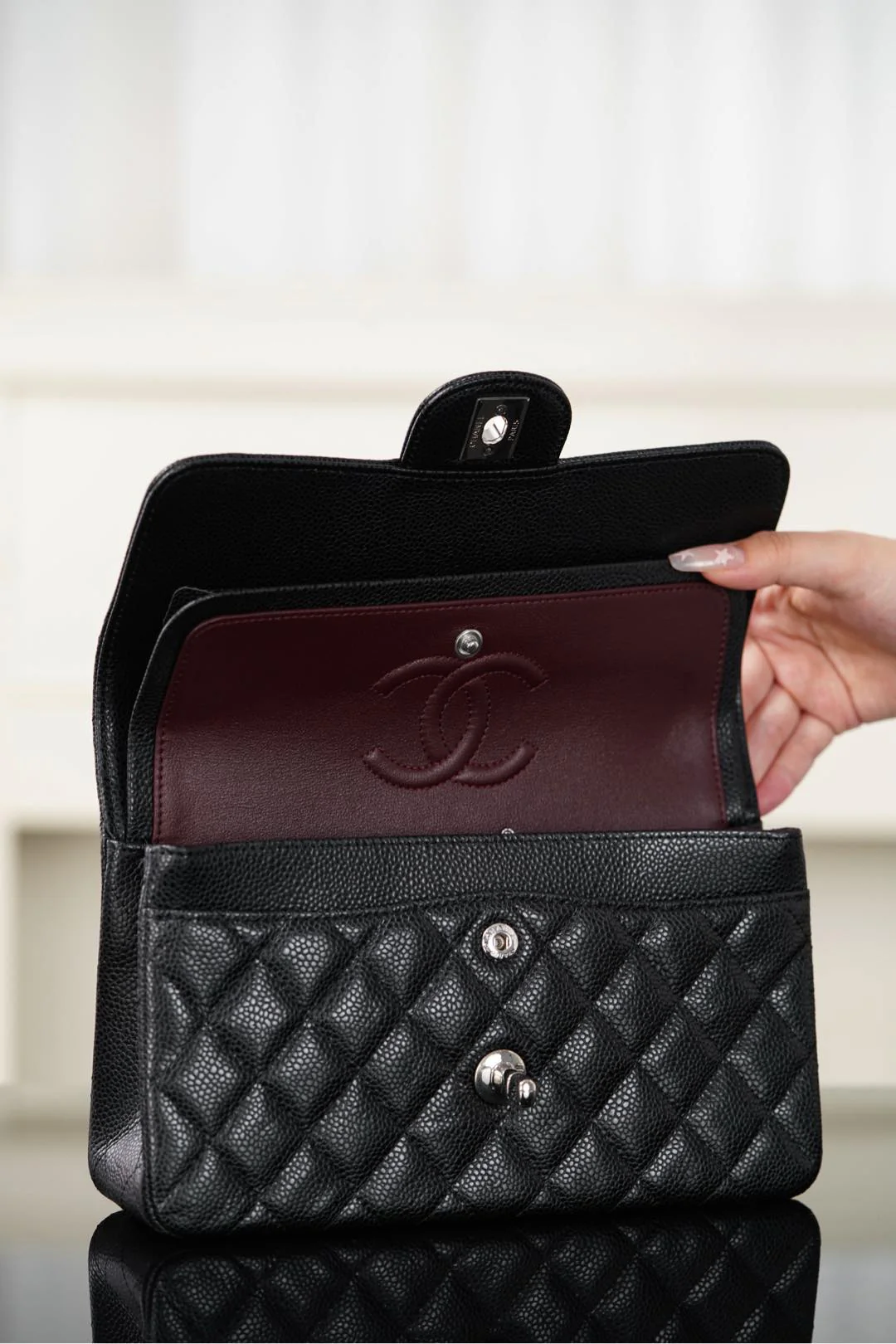 Сумка-гармошка Chanel 25b с двумя ручками в форме буквы С, черная с золотой пряжкой.