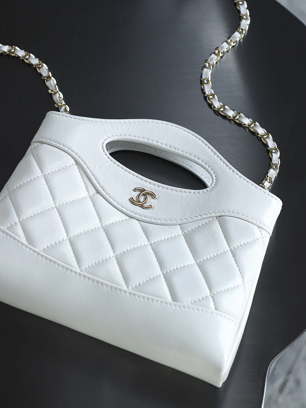 Сумка Chanel Nano 31, горизонтальный вариант, белая с пряжкой из светло-золотистого металла.