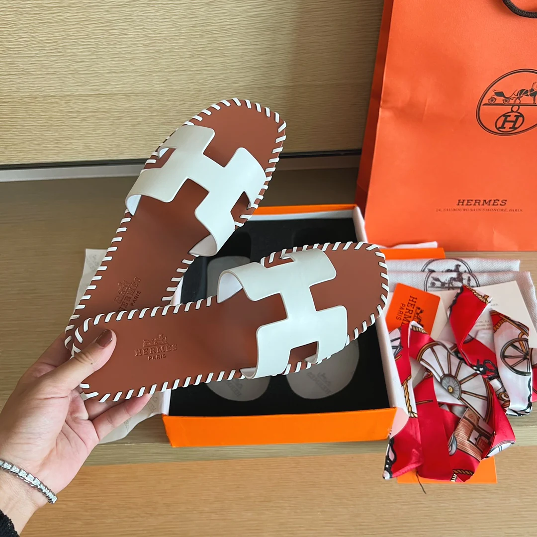 Классические домашние тапочки Hermes с буквой H — верх из однотонной кожи с прошитой подошвой — белые.