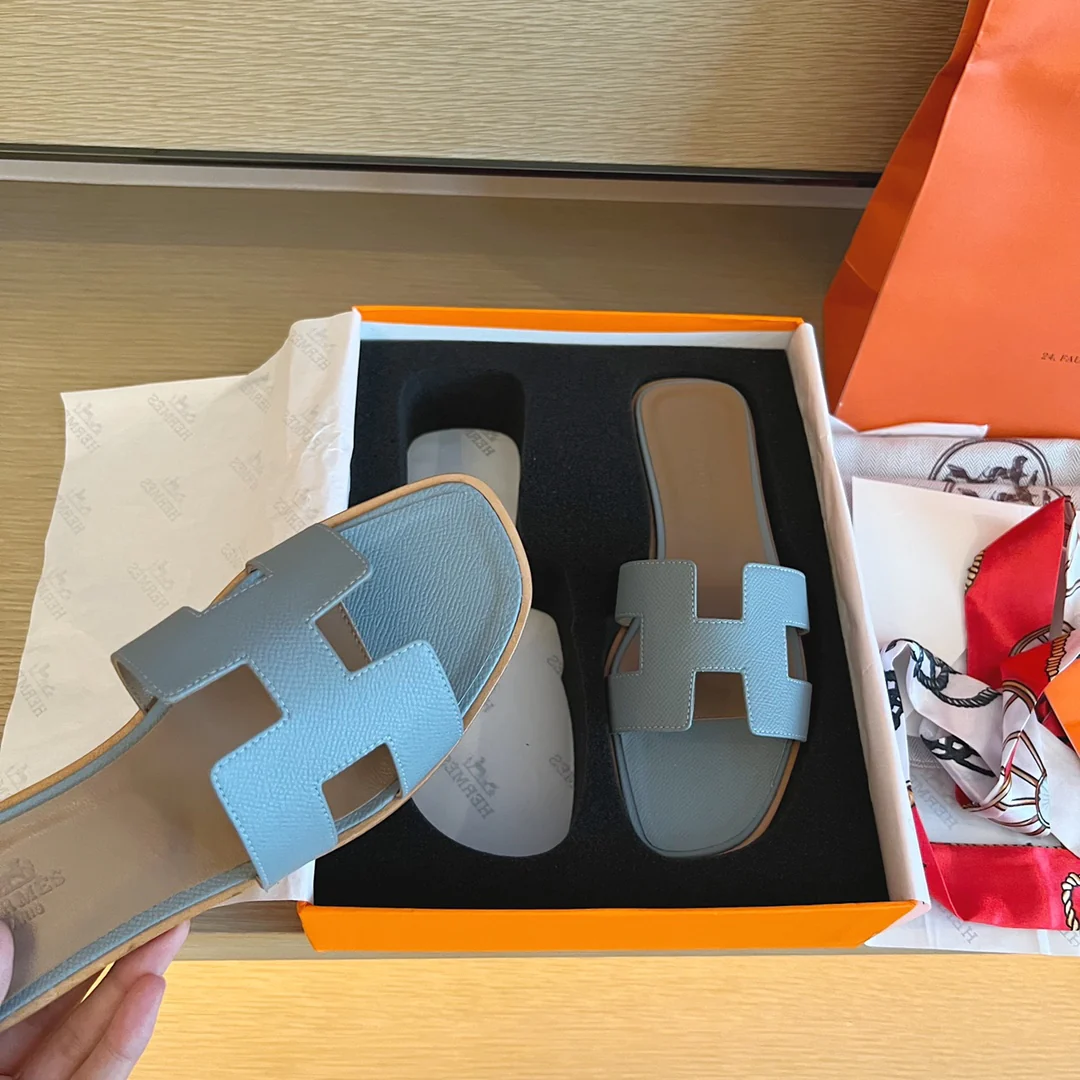 Классические тапочки Hermes с буквой H — светло-голубые с принтом пальм.