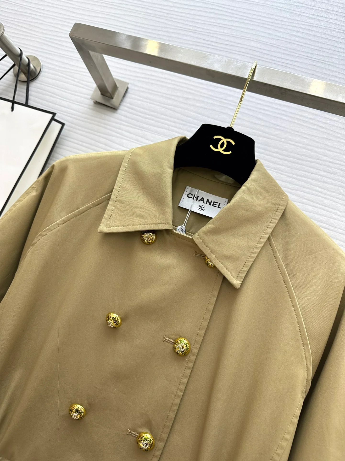 Новая коллекция Chanel весна/лето 2024: двубортный тренч, украшенный цепочками.