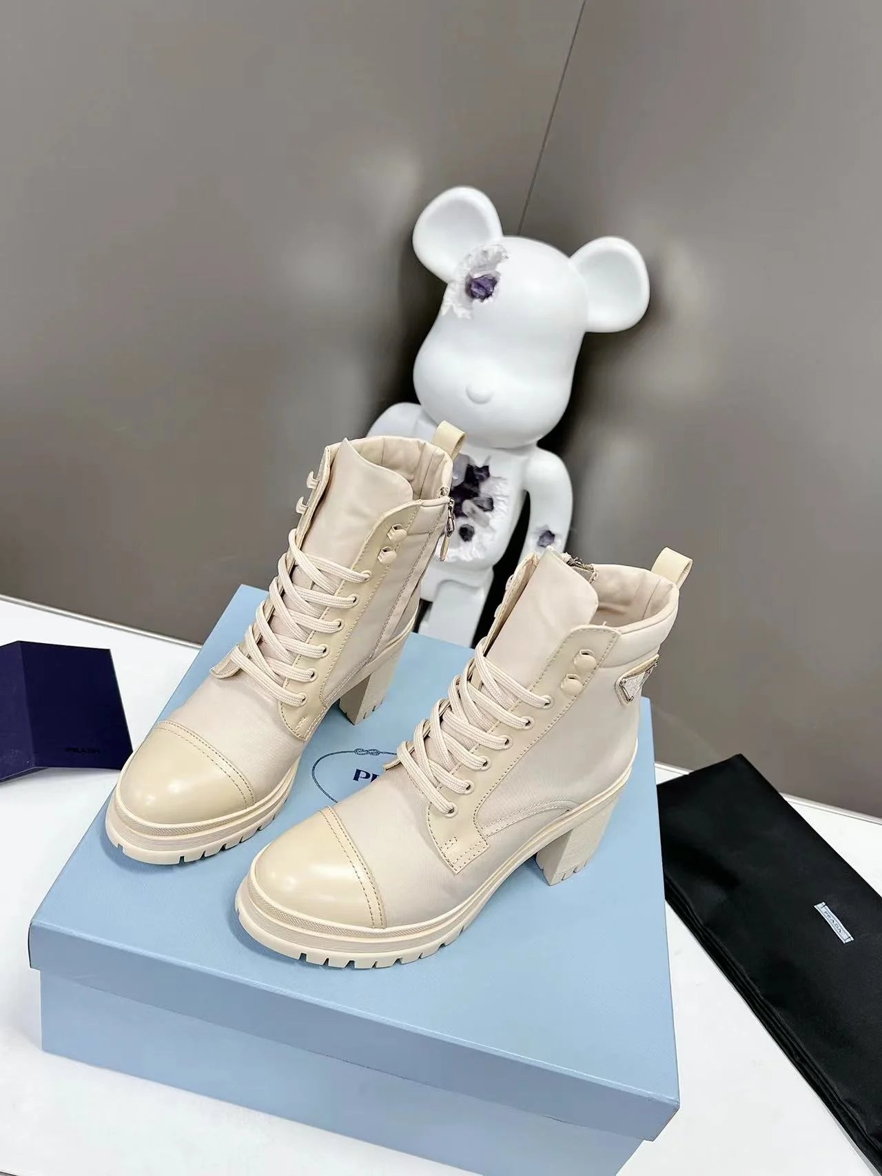 Новинка весны 2022 года от Prada: ботильоны на шнуровке и массивном каблуке — белые.