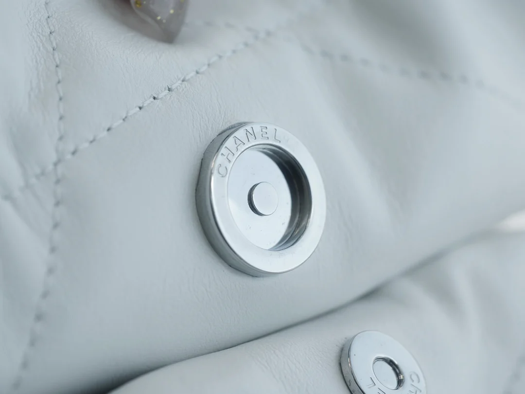 Сумочка Chanel No. 22 — маленькая, белая, серебристая.