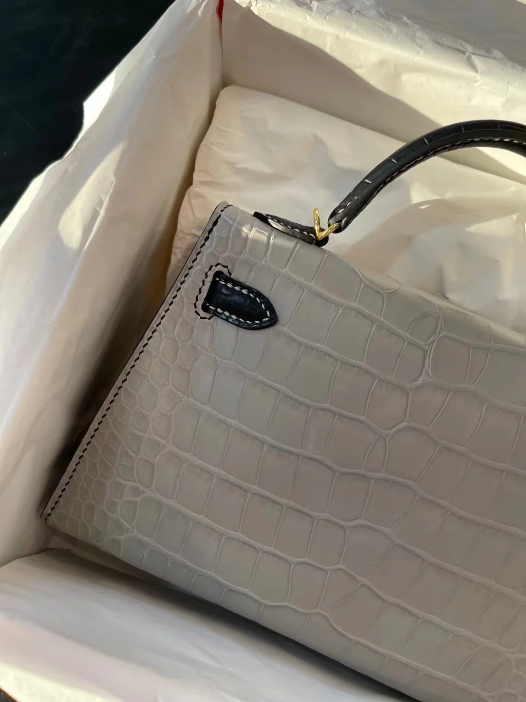 Миниатюрная сумка Hermes Kelly Mini 2-го поколения из матовой кожи аллигатора — жемчужно-серая и черная с золотой фурнитурой.