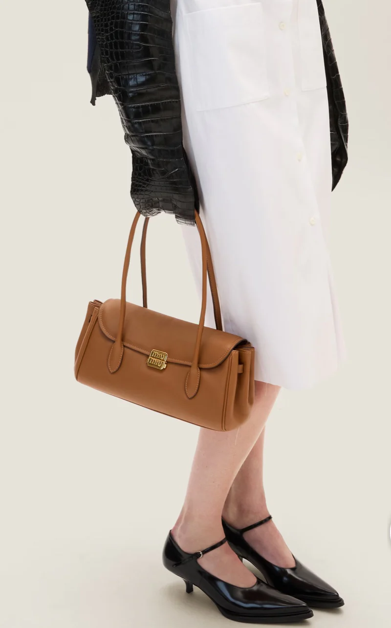 Сумка-багет Miu Miu через плечо — цвет коньяк — фотографии в одежде.